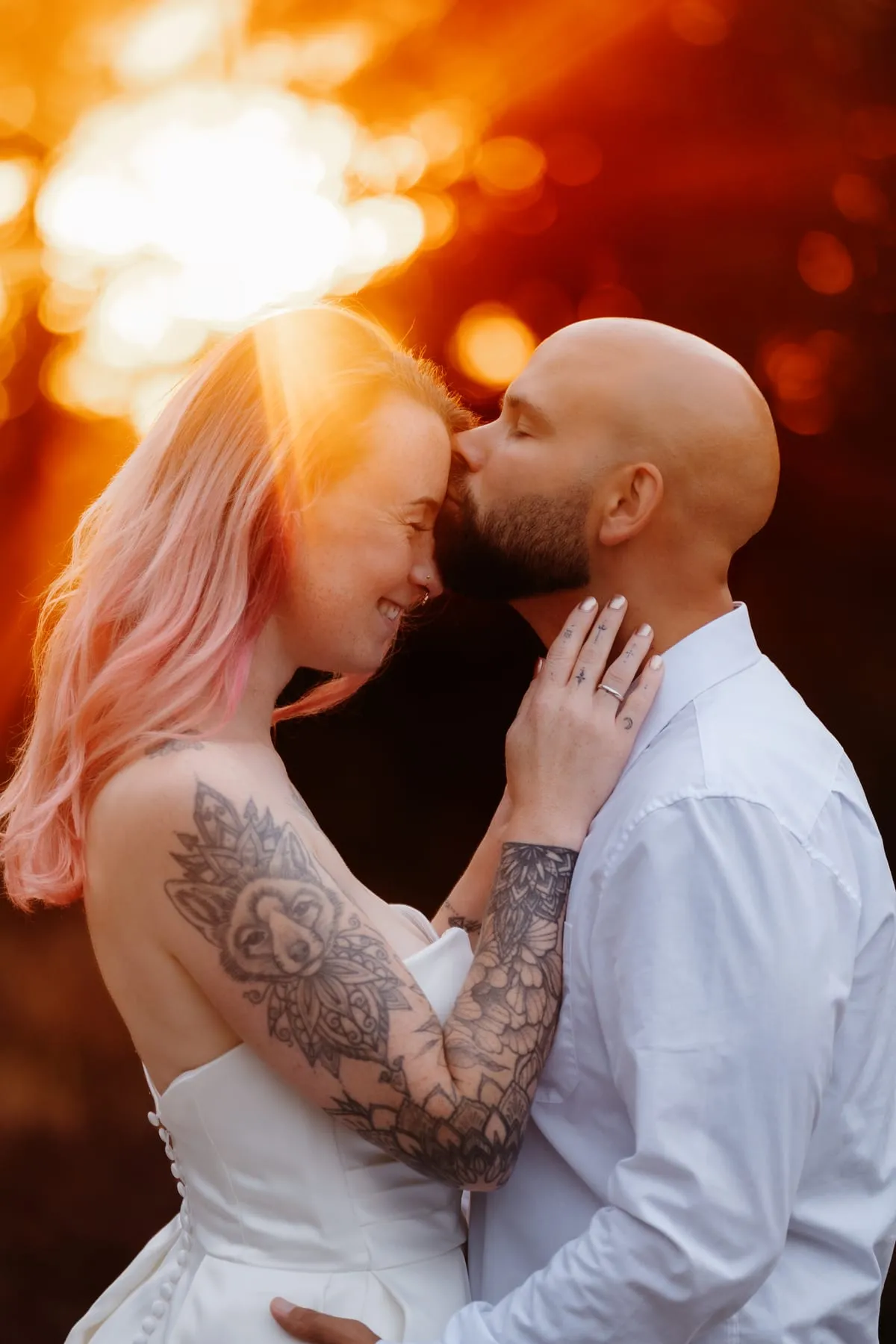 Paar küsst sich im orangefarbenen Gegenlicht, fotografiert von Coralie